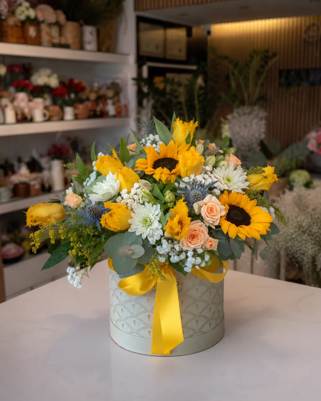 Arranjo floral com girassóis, flores amarelas e rosas suaves preparado pela Paula Florista em Fafe