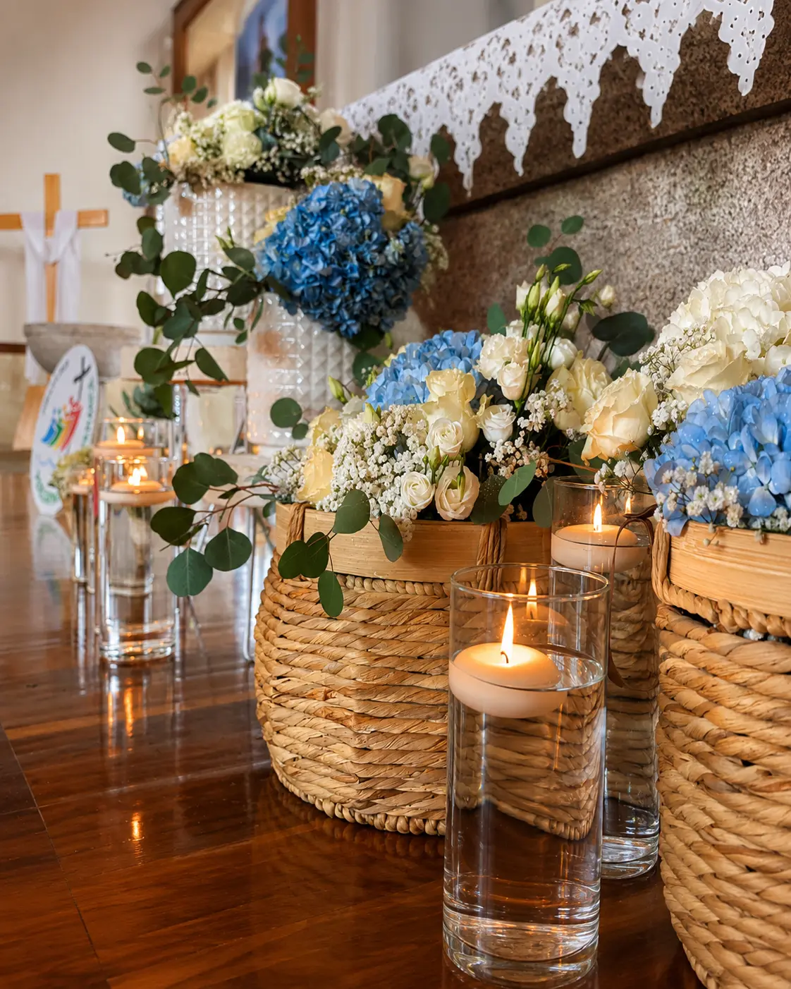 Decoração floral com hortênsias azuis, flores brancas e velas criada pela Paula Florista em Fafe