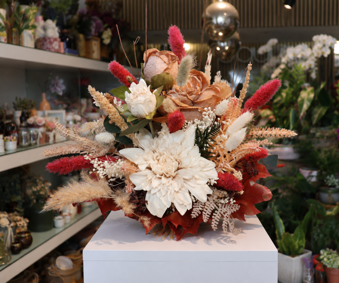 Ramo de flores secas e preservadas em tons vermelhos, creme e pêssego preparado pela Paula Florista em Fafe